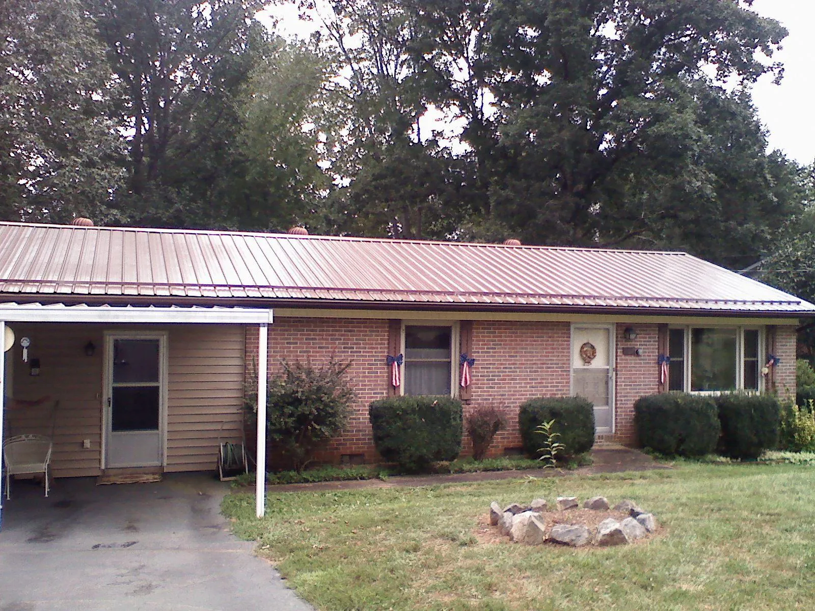 Bronze metal roof and carport on a brick ranch home — Roof Repair work by our crew in Glengary